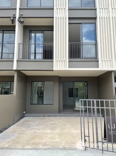 Modern townhouse exterior with sleek design and spacious balcony