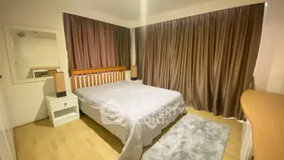 Spacious bedroom with cozy ambiance and elegant curtains, perfect for relaxation.