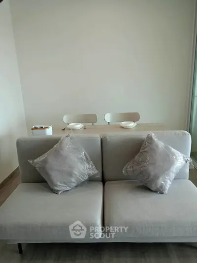 Modern living room with stylish sofa and dining area in open layout apartment.
