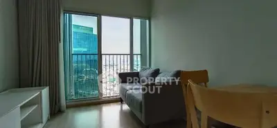 Modern living room with city view and cozy furniture in high-rise apartment.