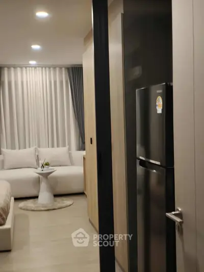 Modern apartment interior with cozy living room and sleek kitchen appliances.