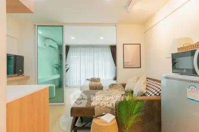 Modern living room with cozy sofa, stylish decor, and natural light from large windows.