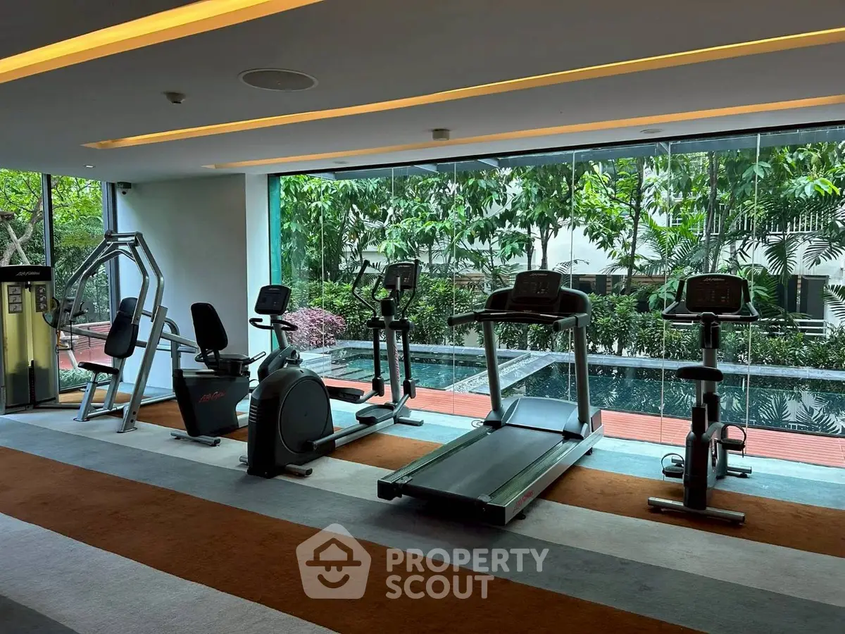 Modern gym with pool view and state-of-the-art fitness equipment