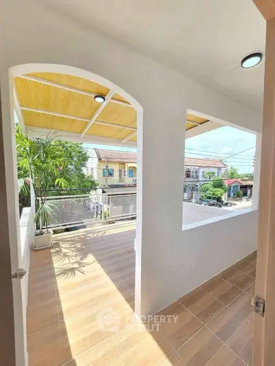 Charming balcony with wooden ceiling and scenic neighborhood view, perfect for relaxation.