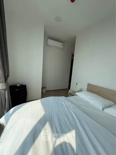 Bright and cozy bedroom with natural light and modern air conditioning unit.