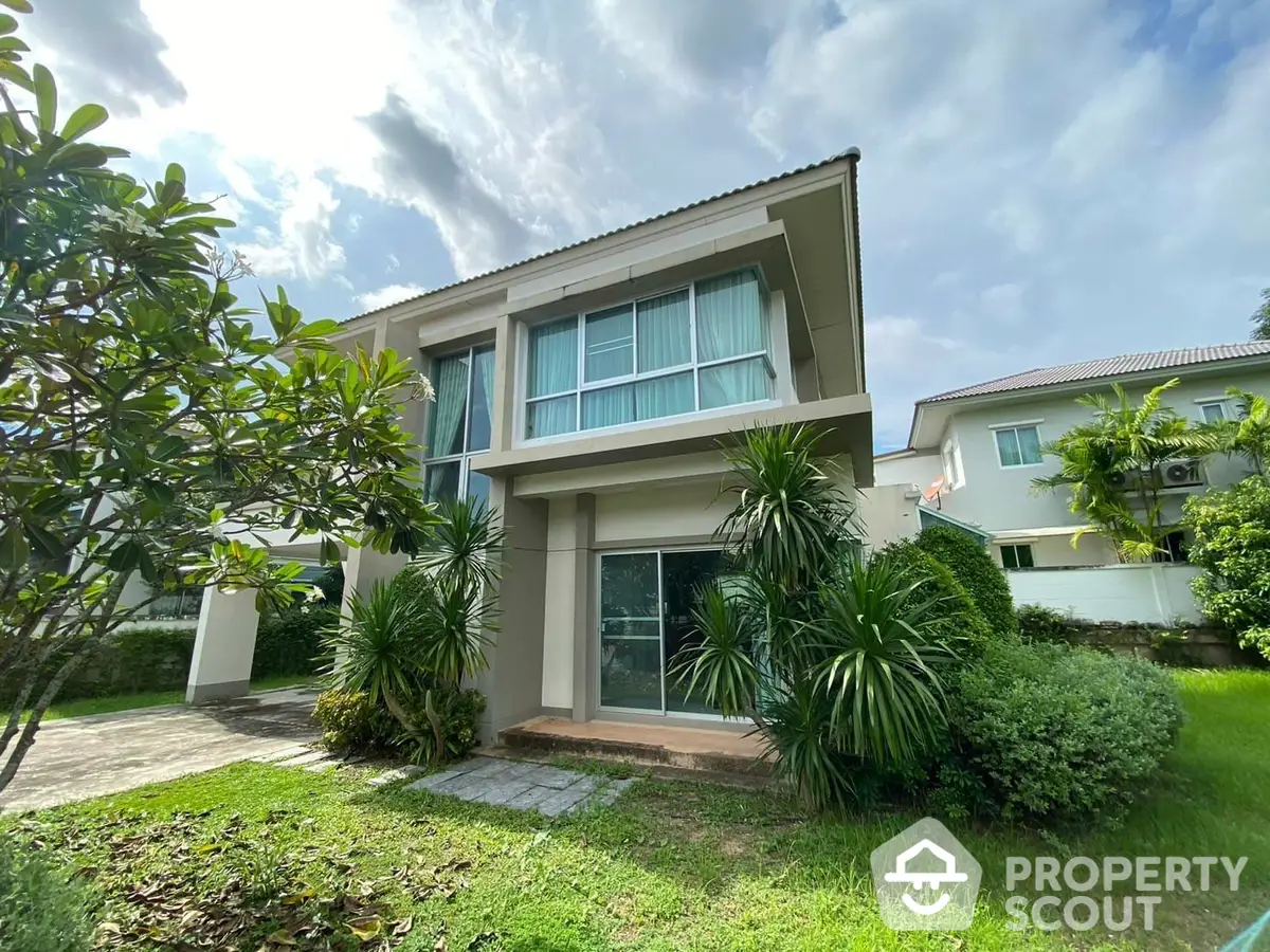 Charming two-story family home with lush garden and ample natural light, featuring large windows and a serene neighborhood setting.