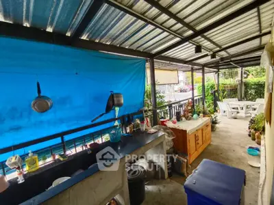 Charming outdoor kitchen with covered patio and garden view, perfect for al fresco dining and entertaining.