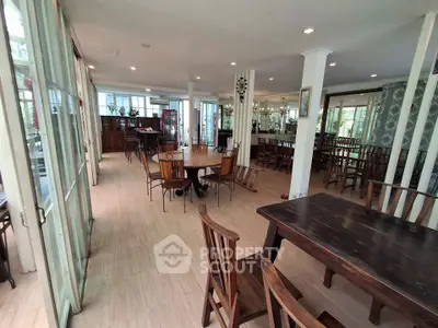 Spacious dining area with elegant wooden furniture and large windows for natural light.
