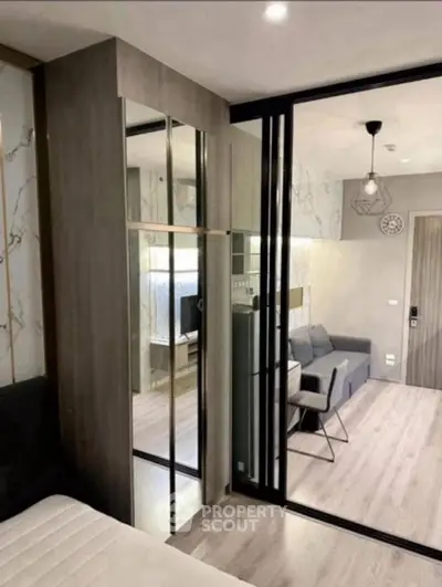 Modern living room with stylish decor and mirrored wardrobe in a contemporary apartment.