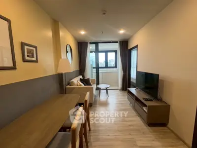 Modern living room with cozy sofa, TV, and dining area in stylish apartment.