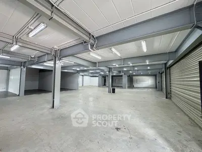 Spacious industrial warehouse with high ceilings and ample lighting, perfect for storage or commercial use.