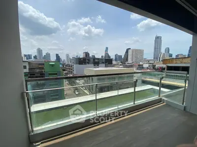 Modern balcony with glass railing offering stunning city skyline views.