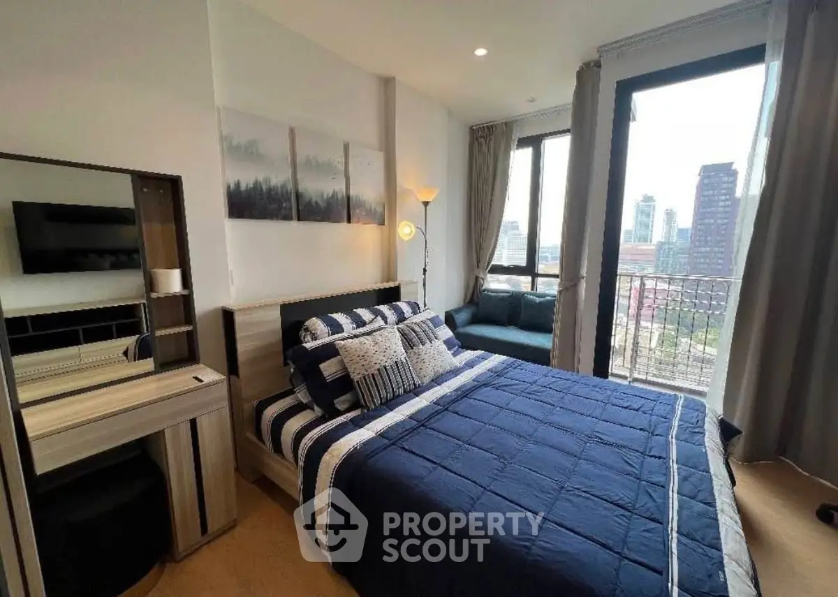 Modern bedroom with city view, stylish decor, and cozy seating area.