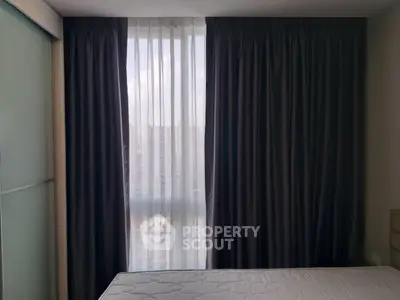Cozy bedroom with large window and dark curtains in modern apartment