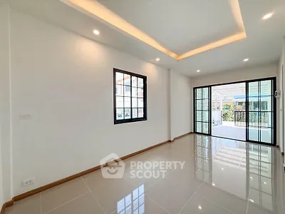 Spacious modern living room with large windows and glossy tiled floors, perfect for natural light and open living.