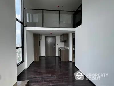 Modern duplex apartment with high ceilings and large windows offering stunning city views.