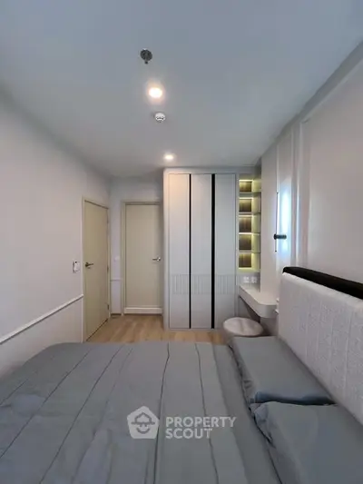 Modern bedroom with sleek built-in wardrobe and cozy bed in a stylish apartment.