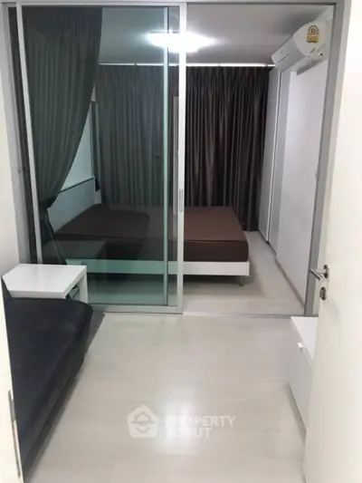 Modern studio apartment with glass partition and sleek furnishings