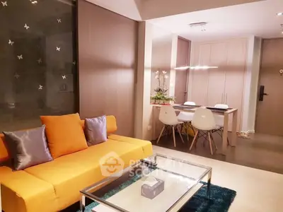 Modern living room with vibrant orange sofa and sleek dining area