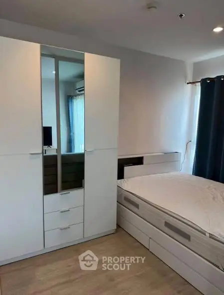 Modern bedroom with sleek white furniture and natural light