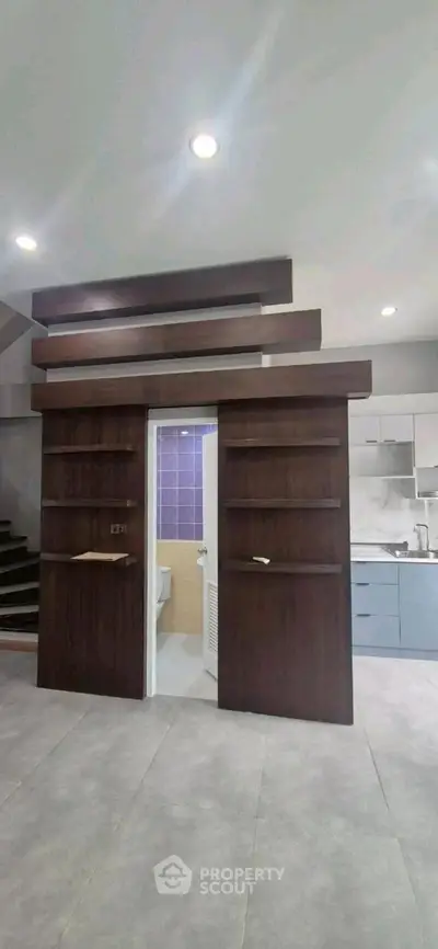 Modern interior with hidden bathroom door and sleek kitchen design