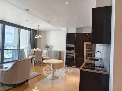Luxurious open-plan living room with modern kitchen and stunning city view.