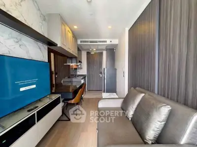 Modern living room with sleek furniture and open kitchen layout in a stylish apartment.