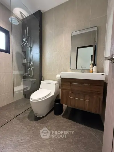 Modern bathroom with glass shower, sleek vanity, and contemporary toilet design.