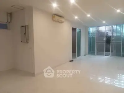 Spacious modern living room with air conditioning and large windows for natural light.
