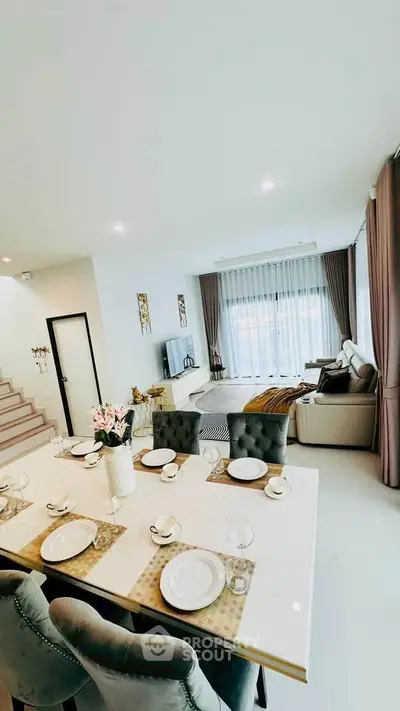 Elegant open-plan living and dining area with stylish decor and natural light.