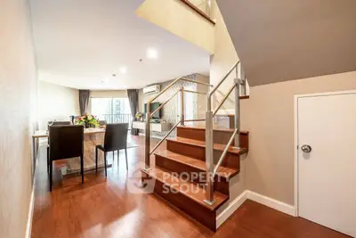 Spacious modern living room with elegant staircase and dining area