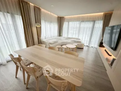 Modern living room with elegant furniture and large windows offering natural light.