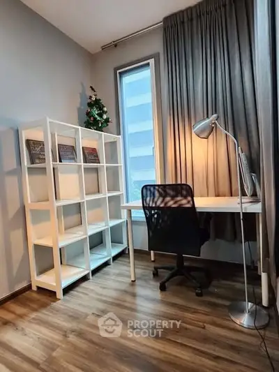 Modern study room with sleek desk, chair, and shelving unit in a bright apartment.