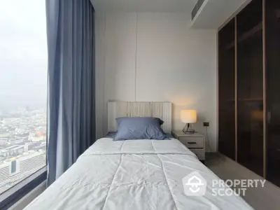 Modern bedroom with city view, featuring sleek design and cozy ambiance.