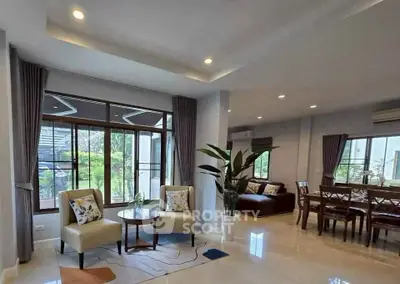 Spacious living room with elegant dining area and garden view, perfect for modern family living.