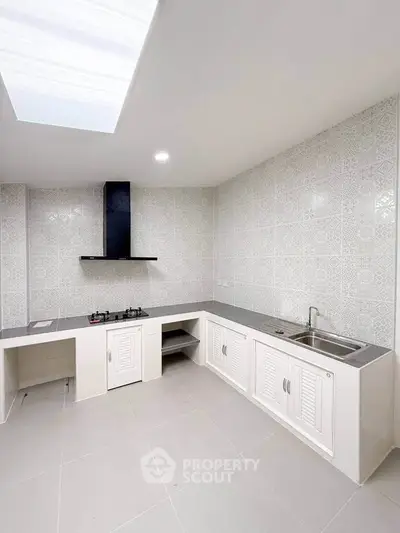 Modern kitchen with sleek design and gas stove, featuring elegant tile backsplash.