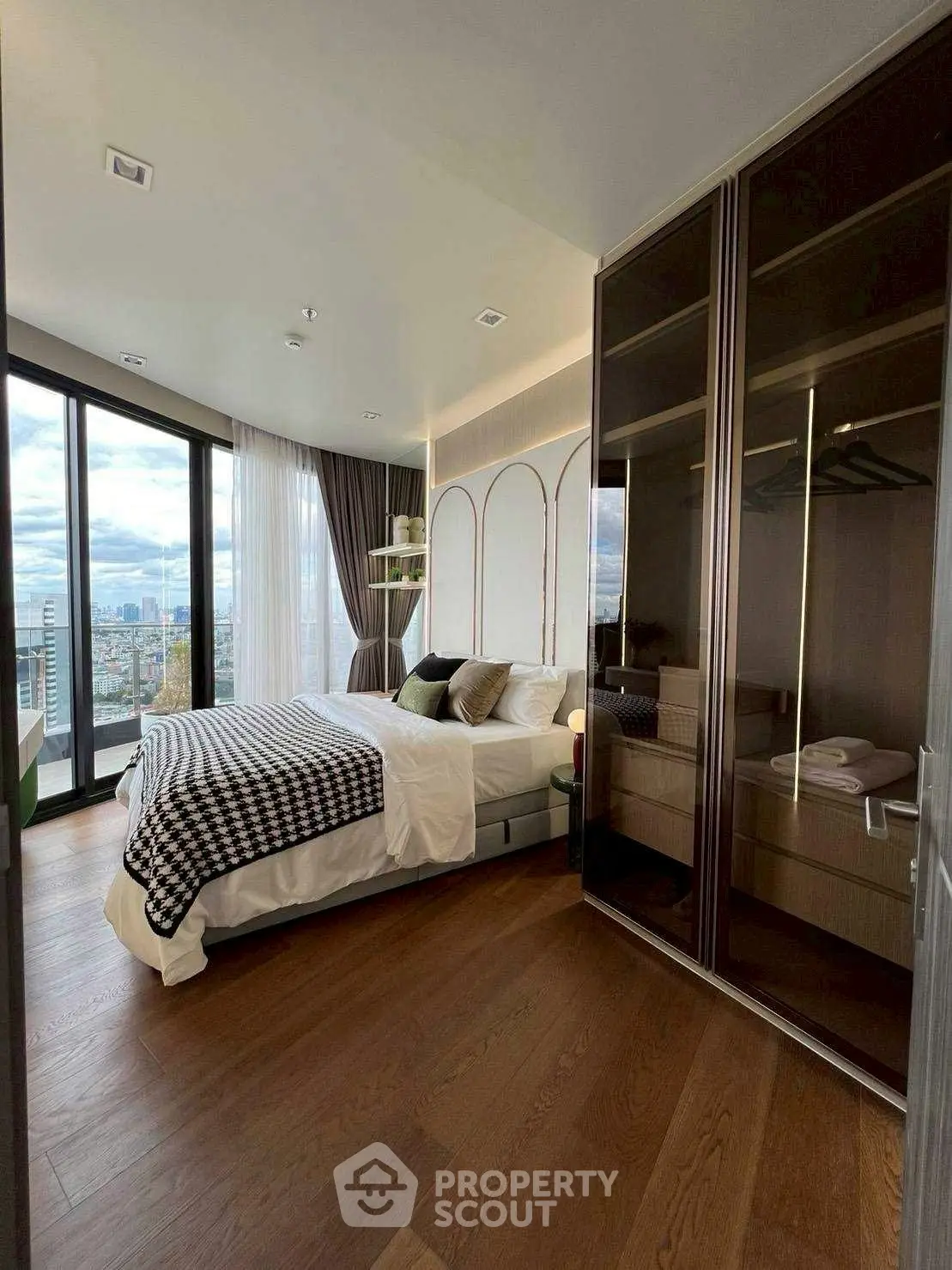 Luxurious bedroom with city view, elegant decor, and spacious wardrobe