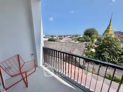 Charming balcony with stunning city view and unique red chair, perfect for relaxation and enjoying the skyline.