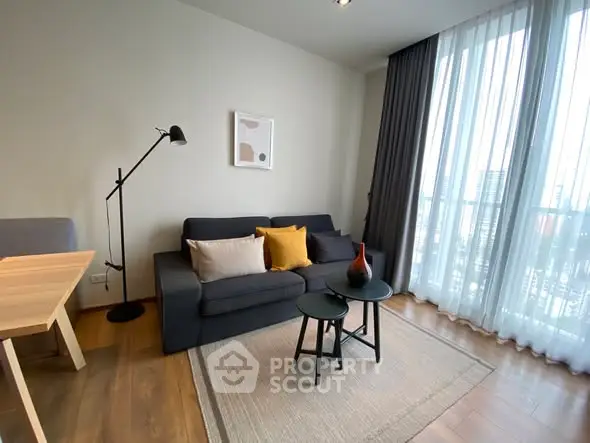 Modern living room with stylish decor and large window view.