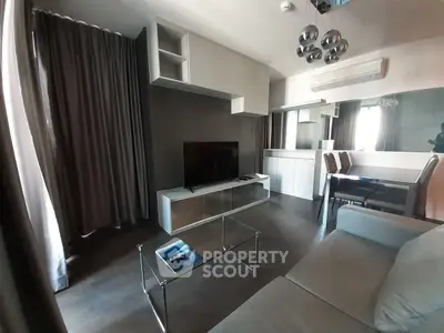 Modern living room with sleek furniture and large TV in stylish apartment.
