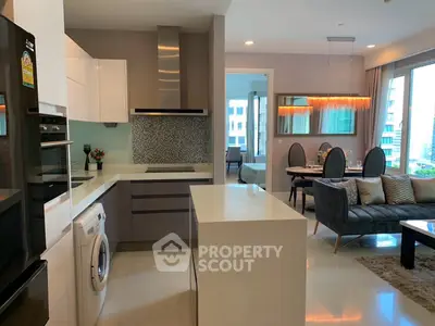 Modern open-layout kitchen and living room with stylish decor and natural light.