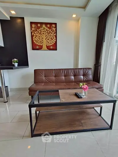 Modern living room with sleek leather sofa and stylish coffee table, featuring elegant wall art and natural light.