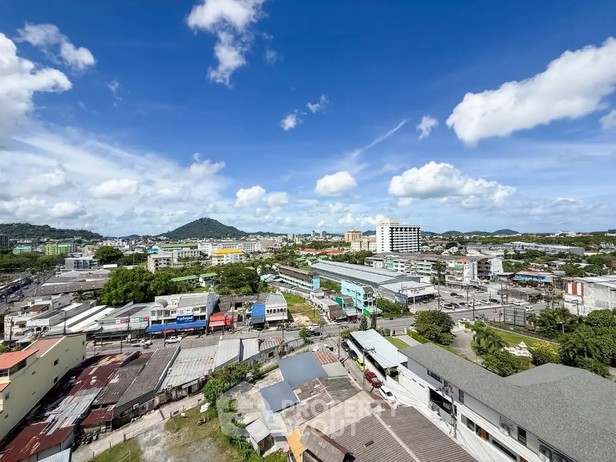Stunning panoramic cityscape view showcasing vibrant urban landscape and distant hills under a clear blue sky.
