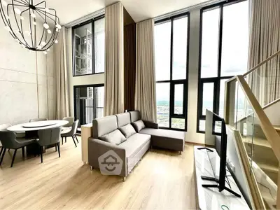 Luxurious modern living room with high ceilings and panoramic windows offering stunning city views.