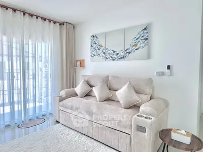 Elegant living room with plush sofa and modern decor in bright natural light.