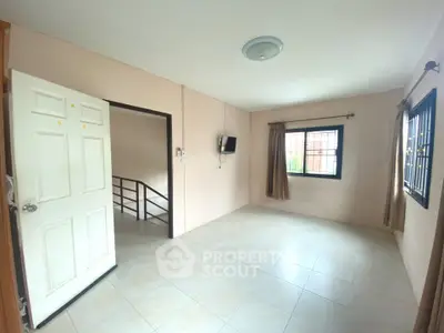 Spacious empty room with tiled floor and natural light, ideal for customization.