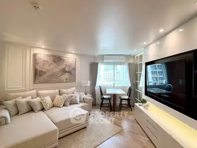 Elegant living room with modern decor and large TV, perfect for relaxation.