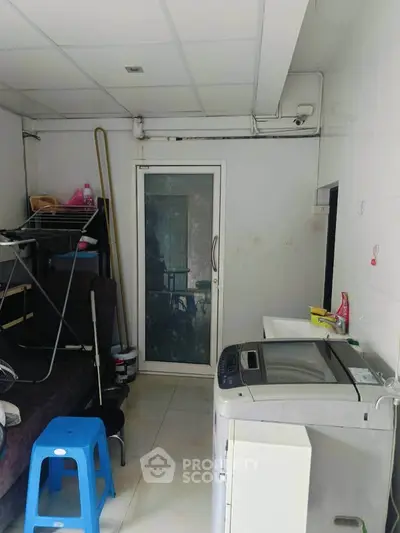 Compact utility room with washing machine and storage space
