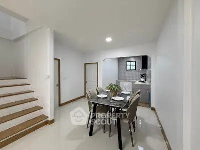 Modern dining area with sleek table and chairs adjacent to a compact kitchen.