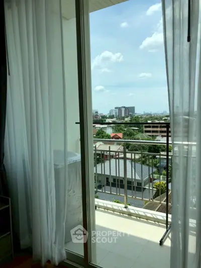 Charming balcony view with cityscape and lush greenery, perfect for relaxation and enjoying the outdoors.